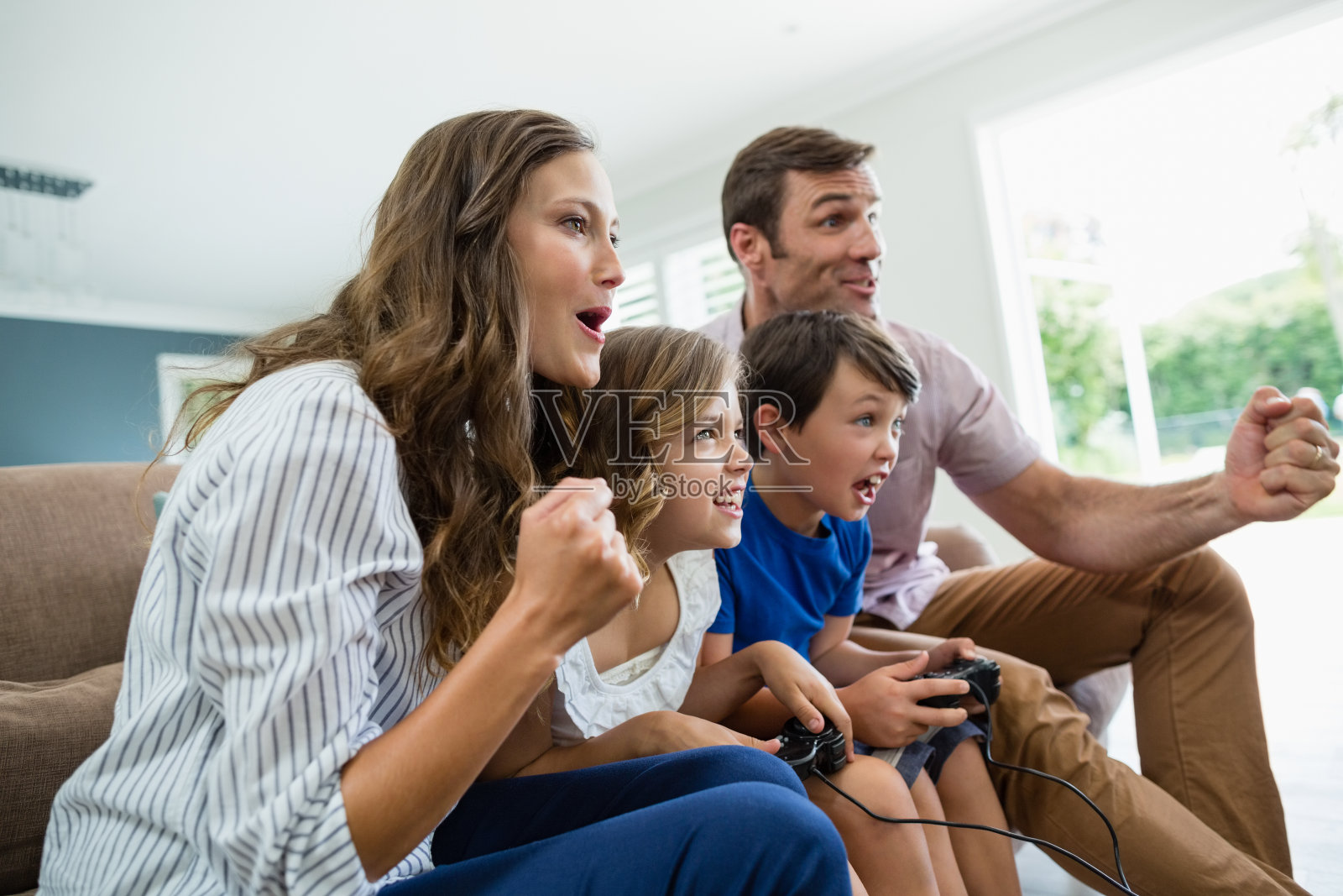 兴奋的家人一起在客厅玩电子游戏照片摄影图片