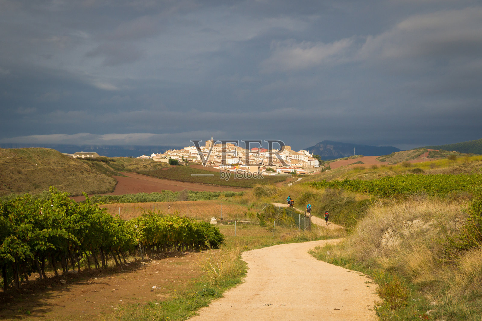 西班牙的小村庄在阳光下闪闪发光，乌云密布照片摄影图片