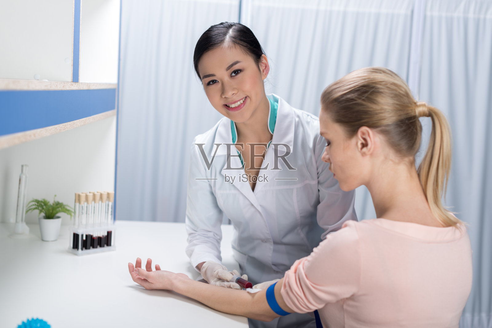 微笑的护士在实验室为病人血样照片摄影图片