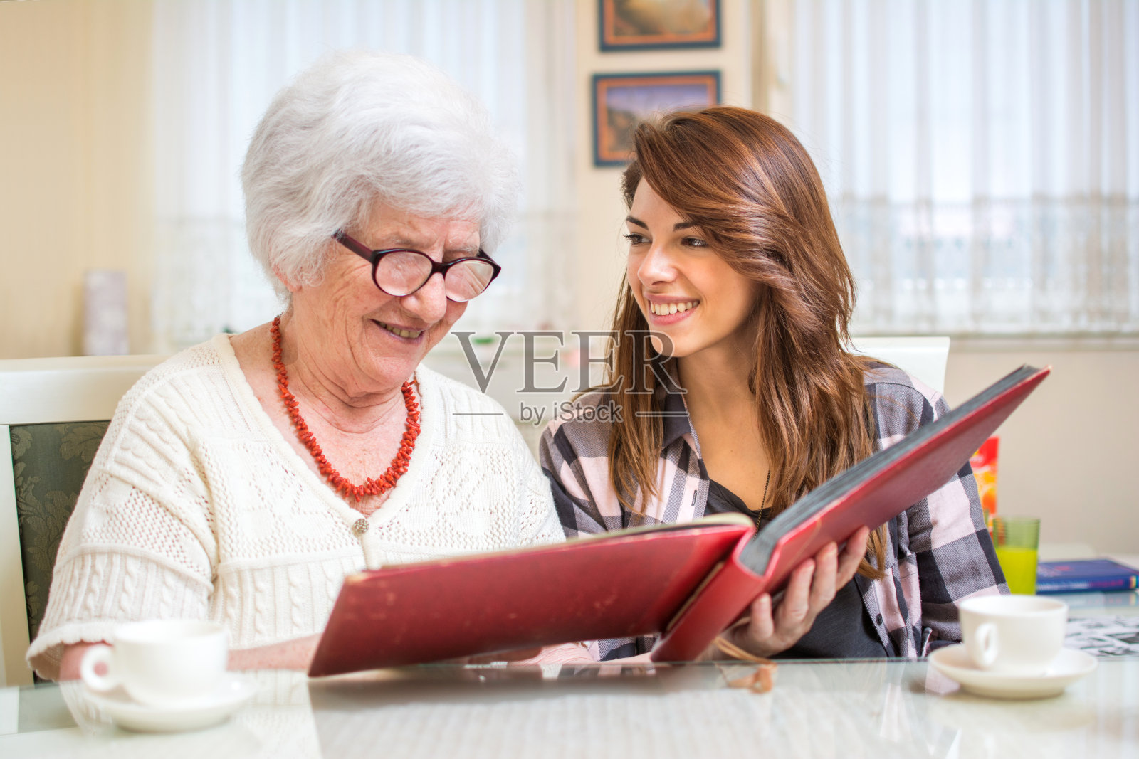 孙女和奶奶一起看相册。照片摄影图片