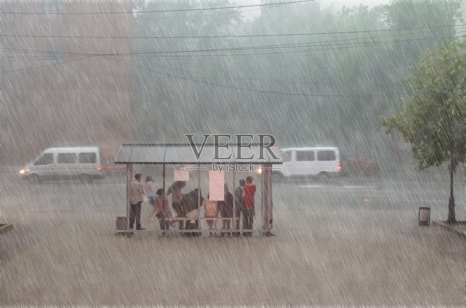 一群人在城市的一个车站躲避大雨。照片摄影图片