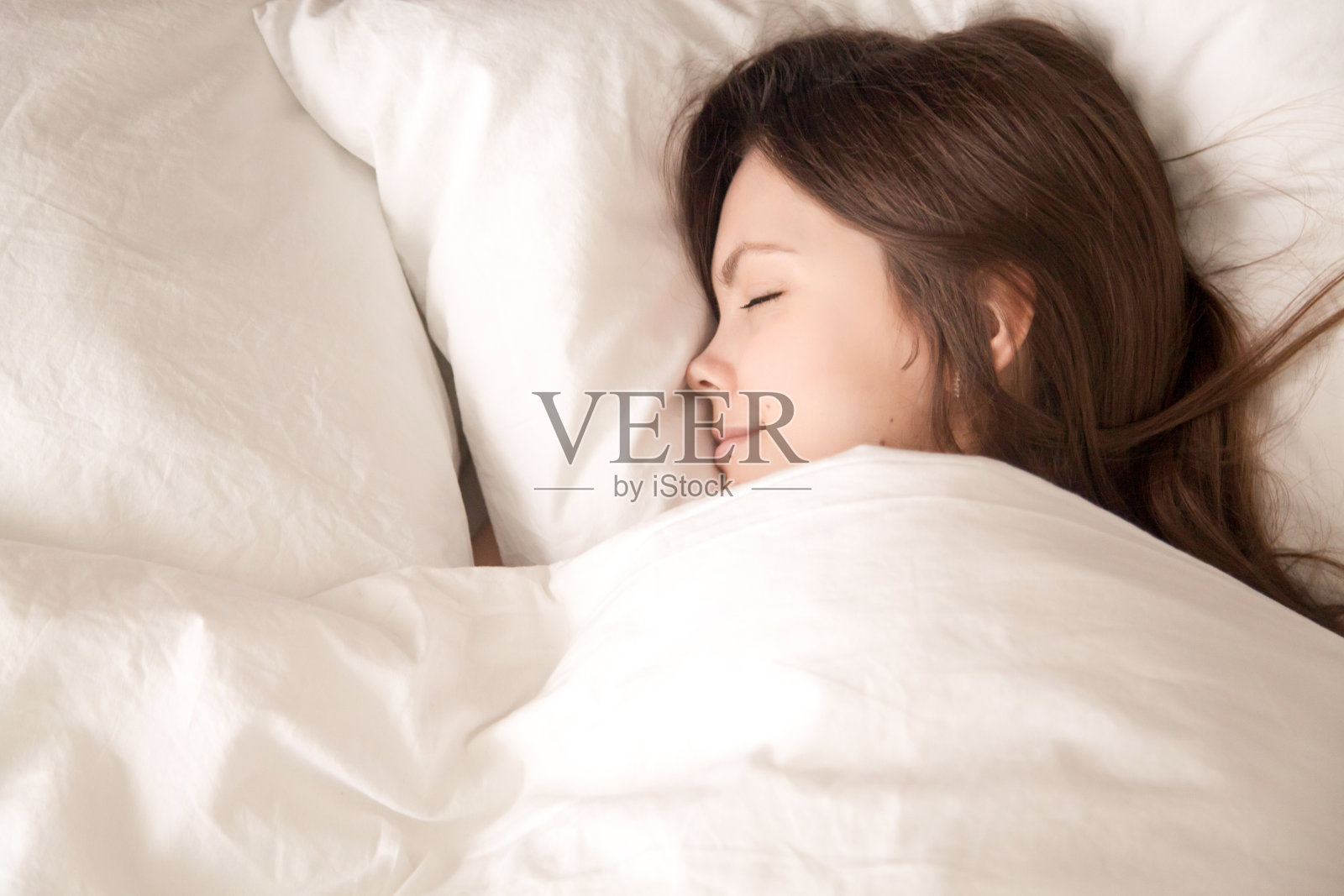 年轻女子睡在温暖的毯子下照片摄影图片
