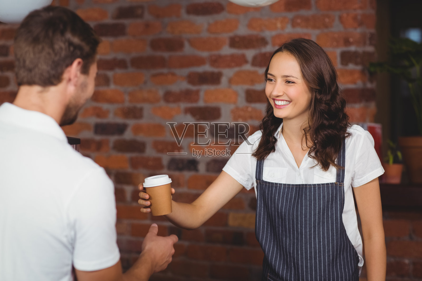 笑容可掬的咖啡师在为顾客服务照片摄影图片