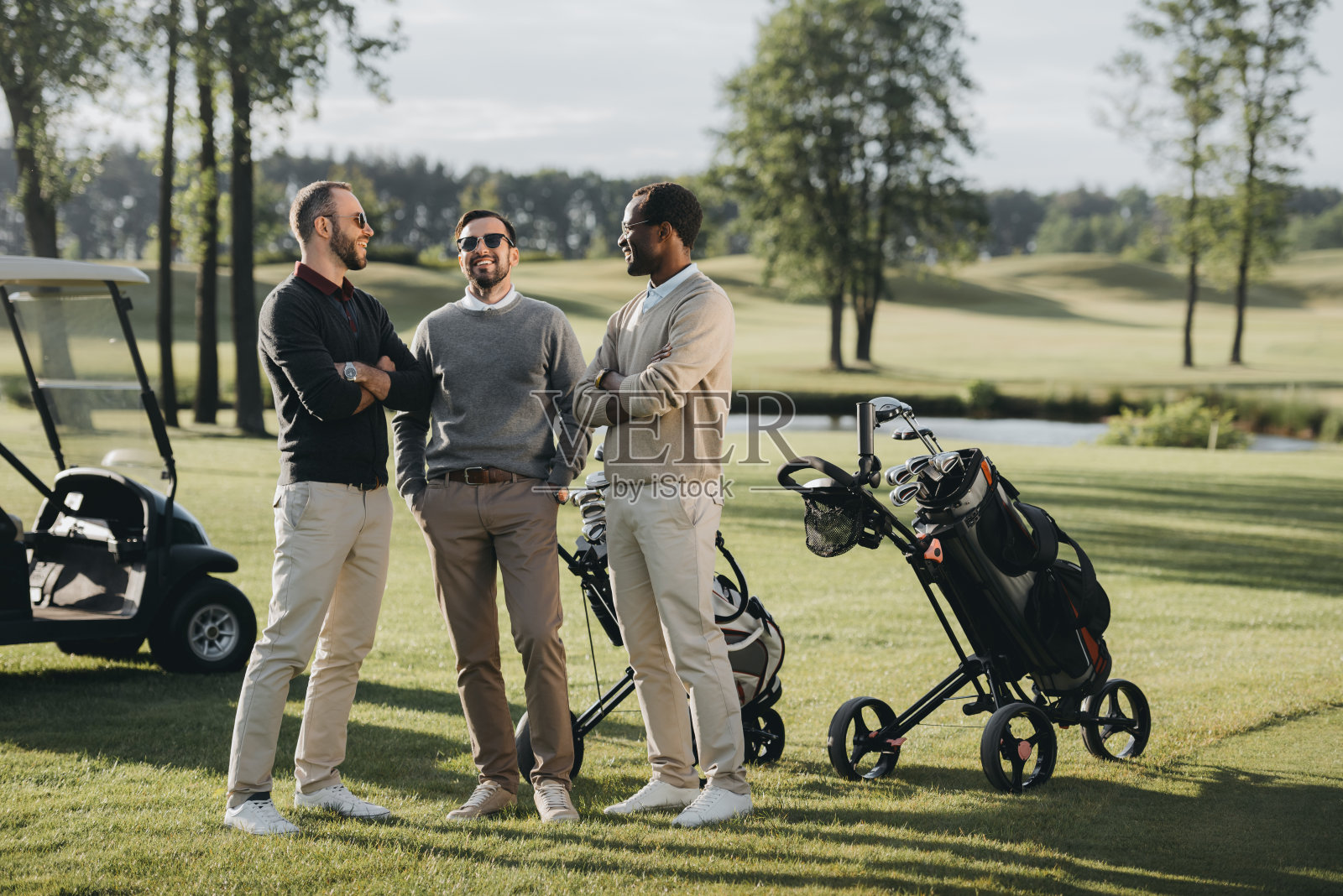 多民族的高尔夫球手与高尔夫俱乐部交谈和花时间在一起高尔夫球场照片摄影图片
