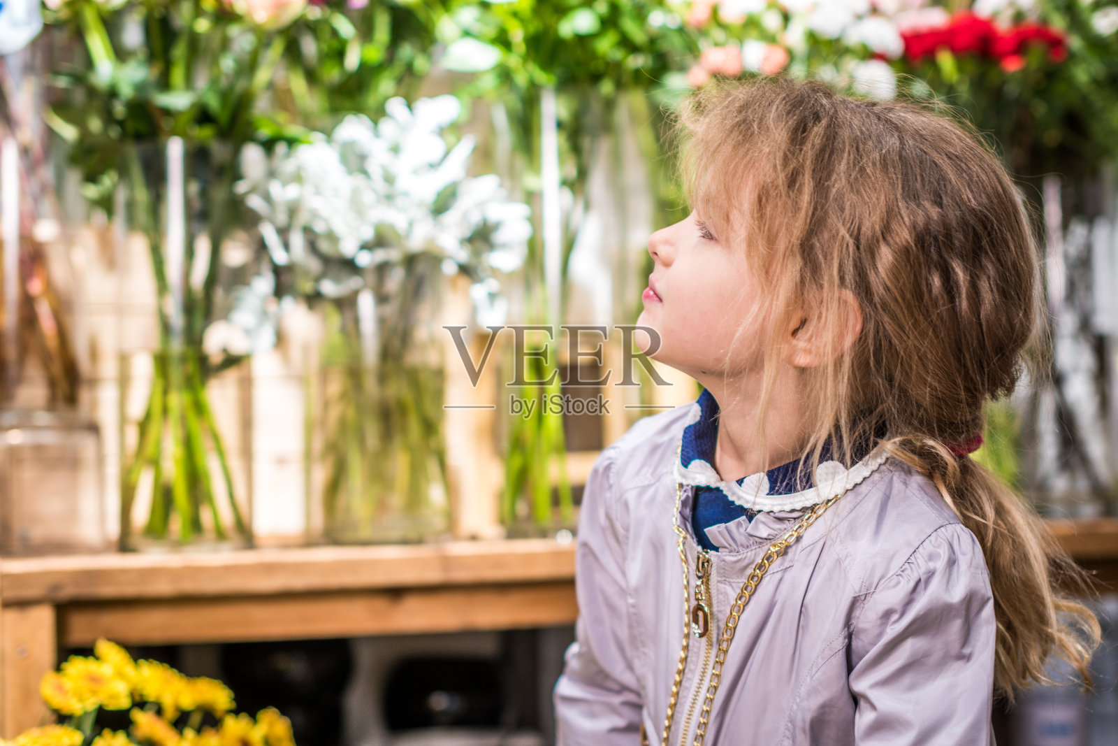 小女孩正站在花市上照片摄影图片