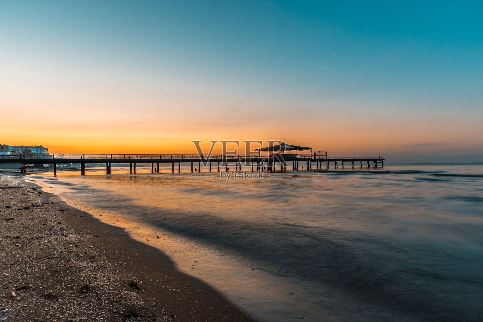 日出时木桥伸向大海照片摄影图片