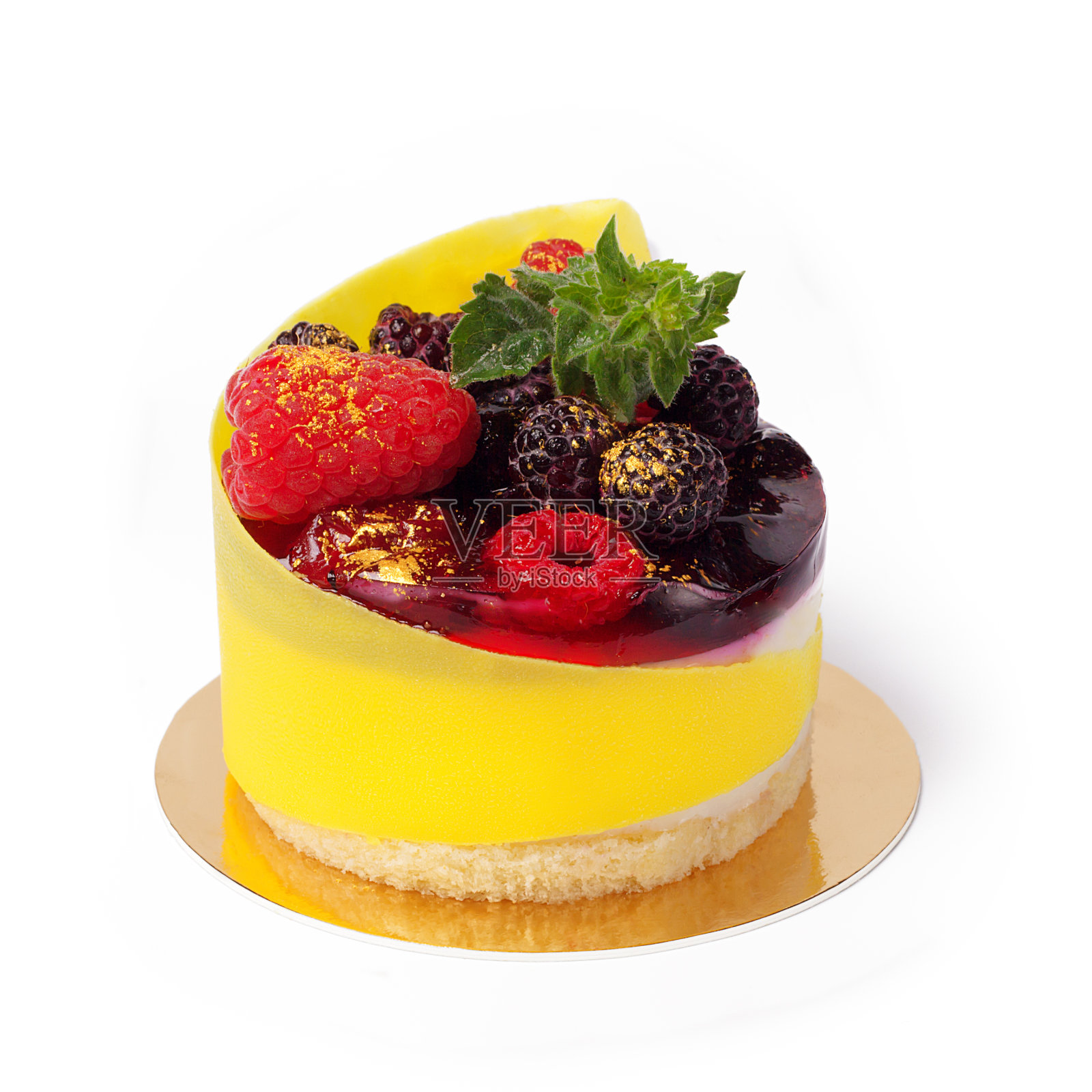 现代法国慕斯蛋糕与新鲜的黑莓，树莓和薄荷枝隔离在白色。饼干和果冻甜点装饰黄色可食用包装纸和金色粉末特写。照片摄影图片