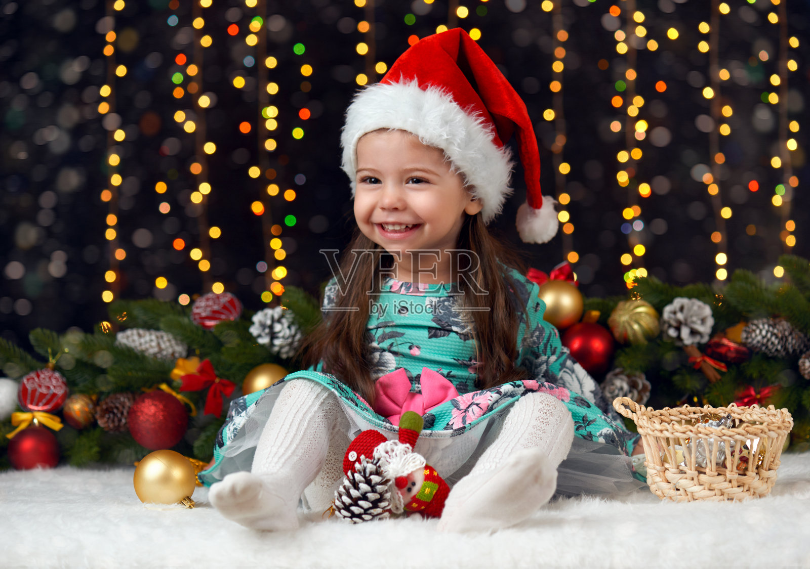 女孩在圣诞节用礼物装饰，黑色背景用照明和博克灯，冬季节日的概念照片摄影图片