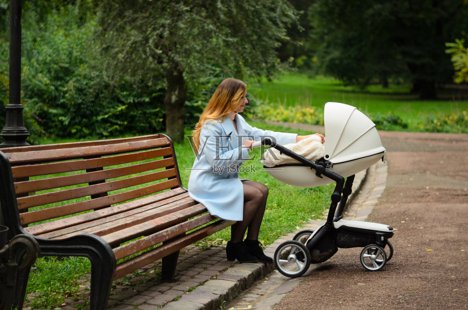 家庭，孩子和母亲的概念-快乐的母亲与婴儿车在公园散步照片摄影图片