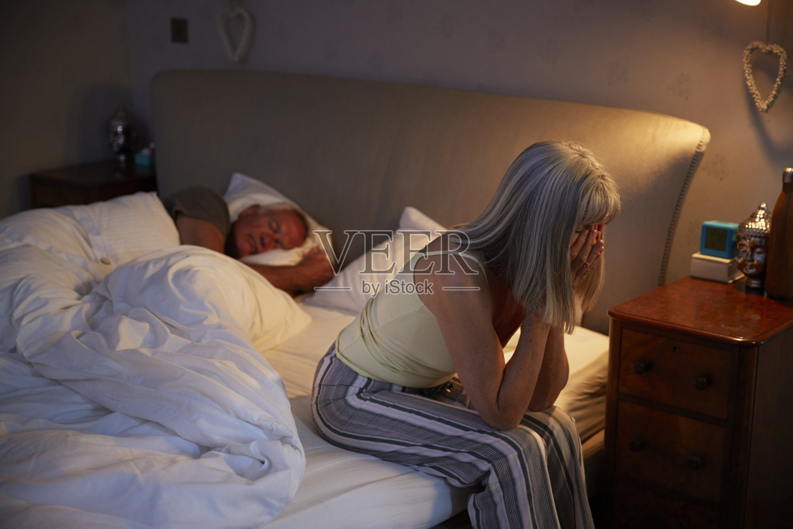 担心的老女人在床上晚上遭受失眠照片摄影图片