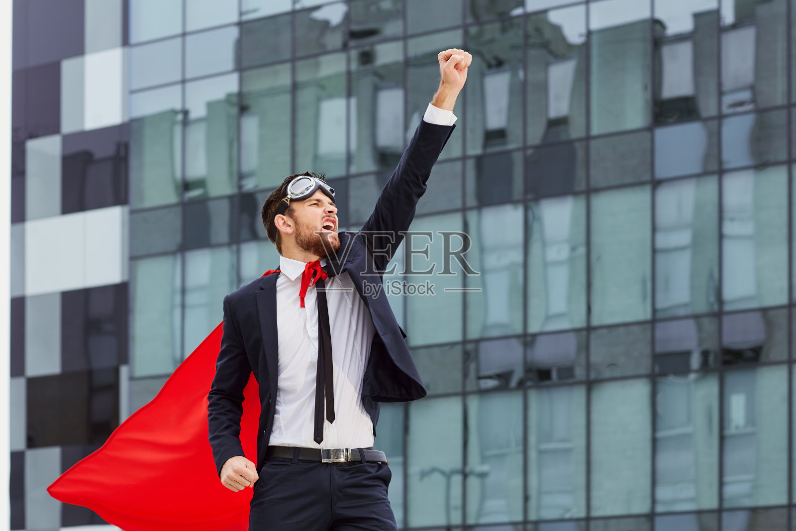 一个超级英雄商人举起他的手反对一个企业照片摄影图片