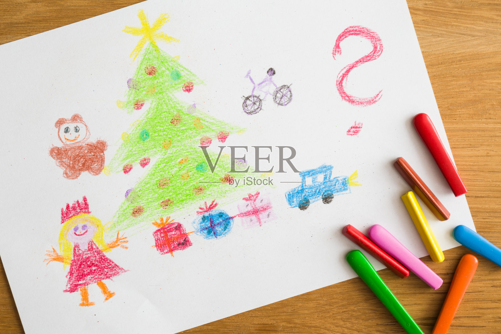 用礼物、礼物、玩具、圣诞树、问号和蜡笔在木桌上画画。圣诞老人和父母，向孩子们献上祝福。儿童艺术的概念。前视图。照片摄影图片