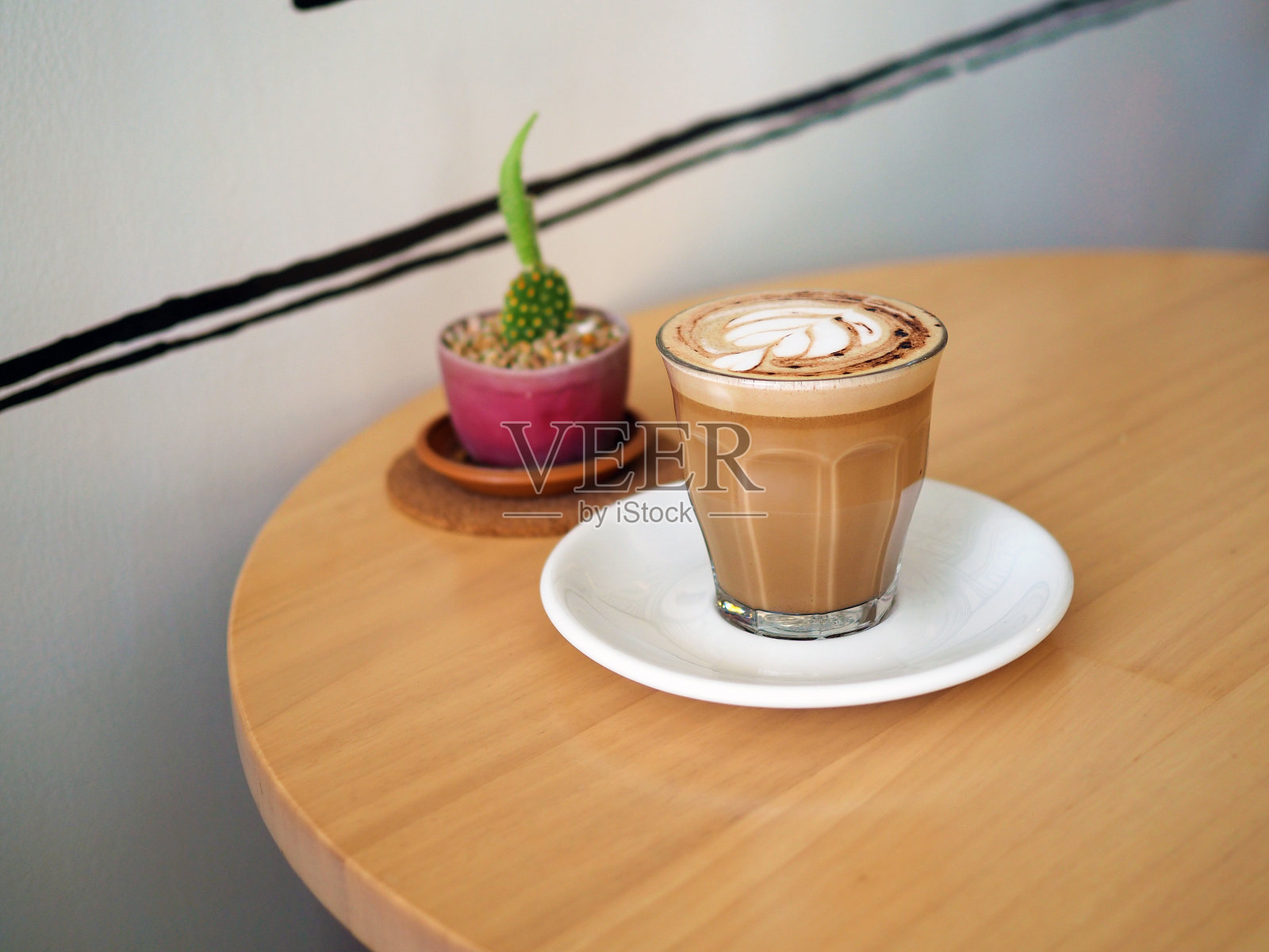 一杯漂亮的热咖啡和拿铁艺术在木托盘上。照片摄影图片