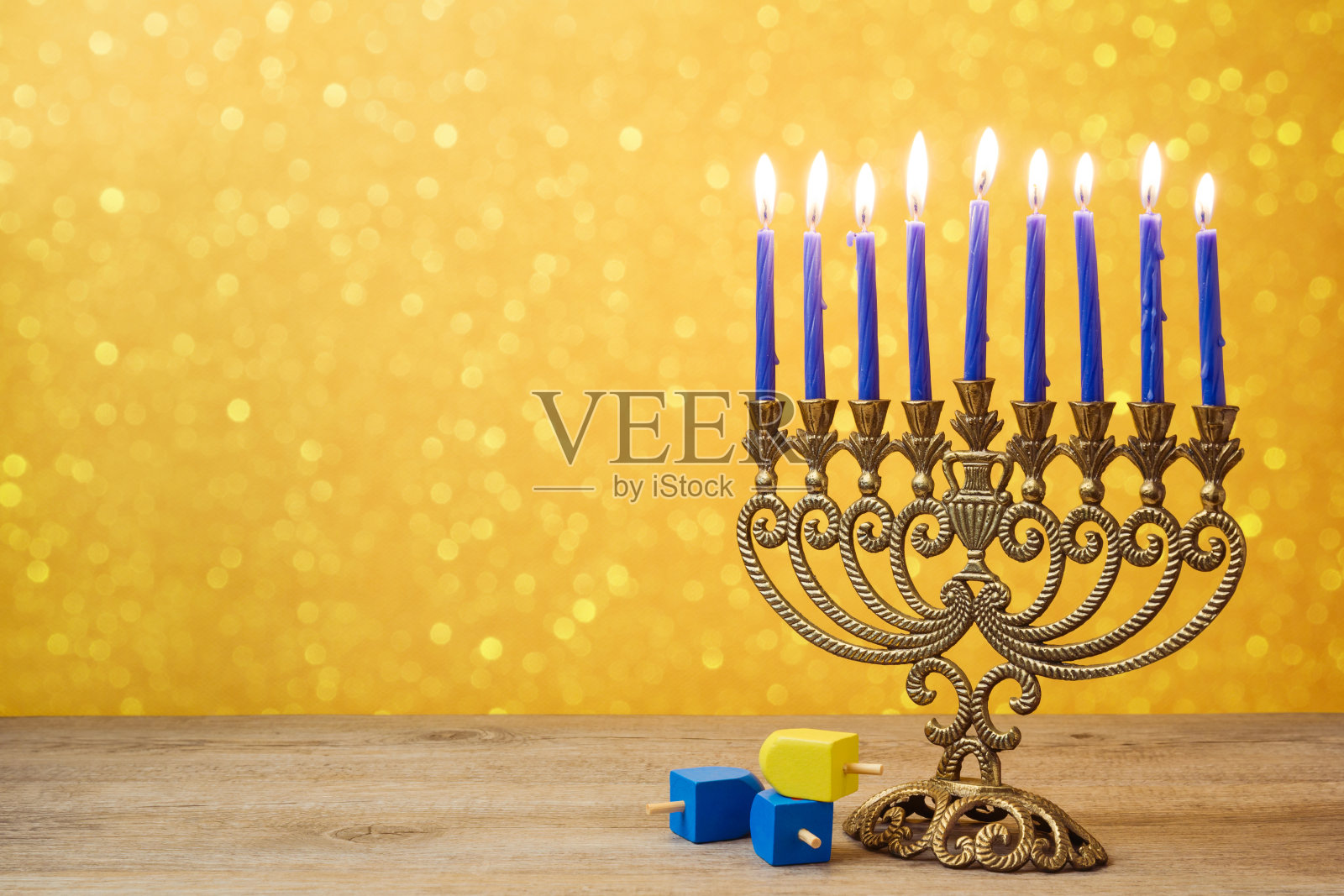 犹太节日光明节背景与复古烛台和旋转陀螺在灯光散焦。照片摄影图片