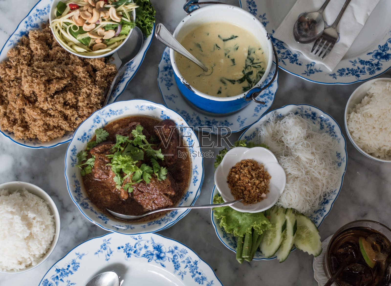 各种各样的亚洲当地食物和米饭在蓝白色的盘子照片摄影图片