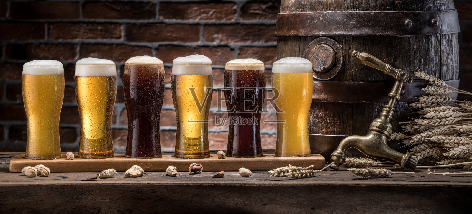 木桌上摆着一桶桶啤酒和麦酒。工艺啤酒。照片摄影图片