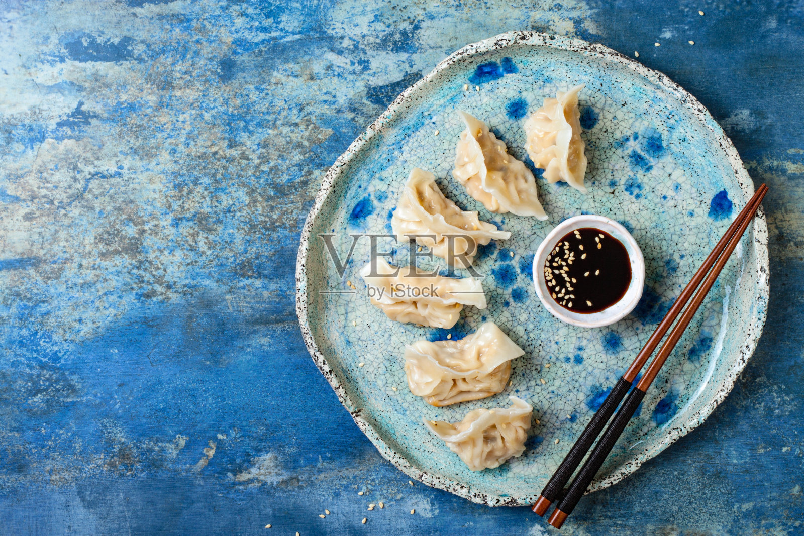 加酱油、芝麻和筷子的亚洲饺子。传统的中国点心饺子。复制空间，平铺照片摄影图片