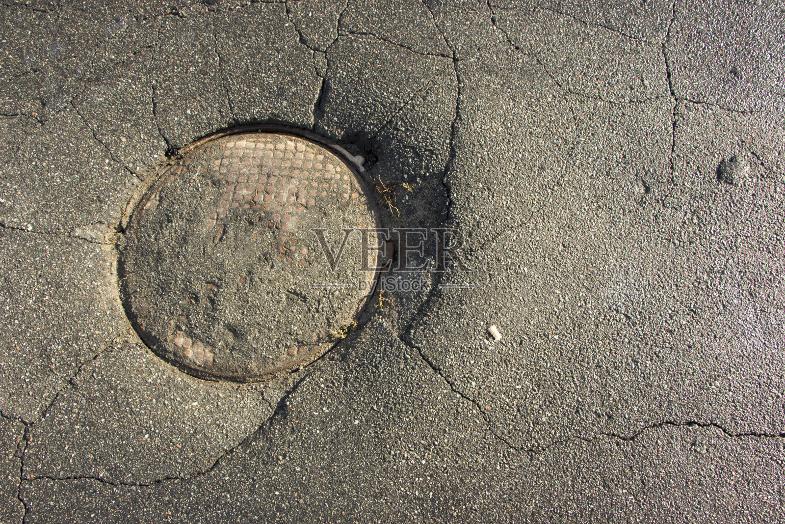 沥青路面大坑、道路污水井圆形井盖照片摄影图片
