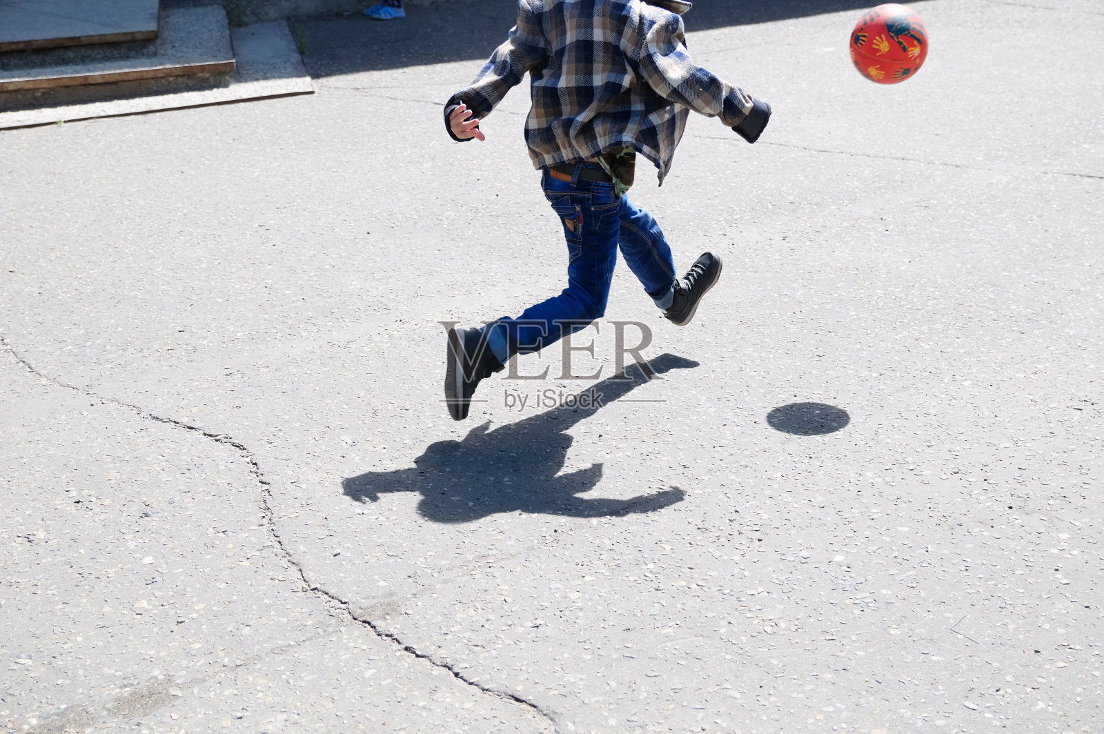 男孩在跳跃，孩子追球在沥青上踢足球，球跳，足球队队员，训练户外，积极的生活方式照片摄影图片