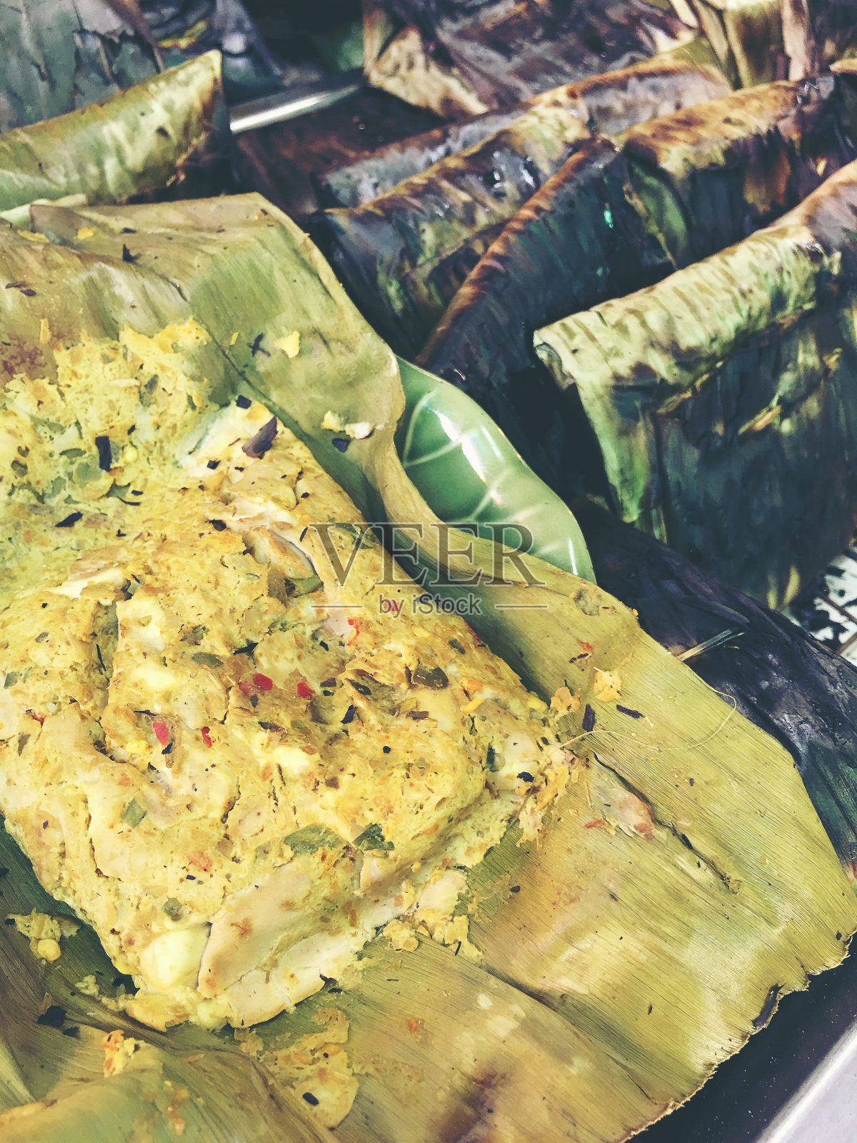 烤猪脑、鸡蛋和泰国香草配香蕉叶，这是泰国北部的传统食物。复古色调和复古滤镜。照片摄影图片