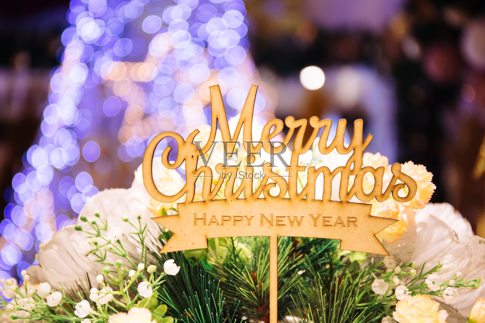 圣诞快乐和新年快乐的文字标志顶部棍与圣诞树在背景散焦照片摄影图片