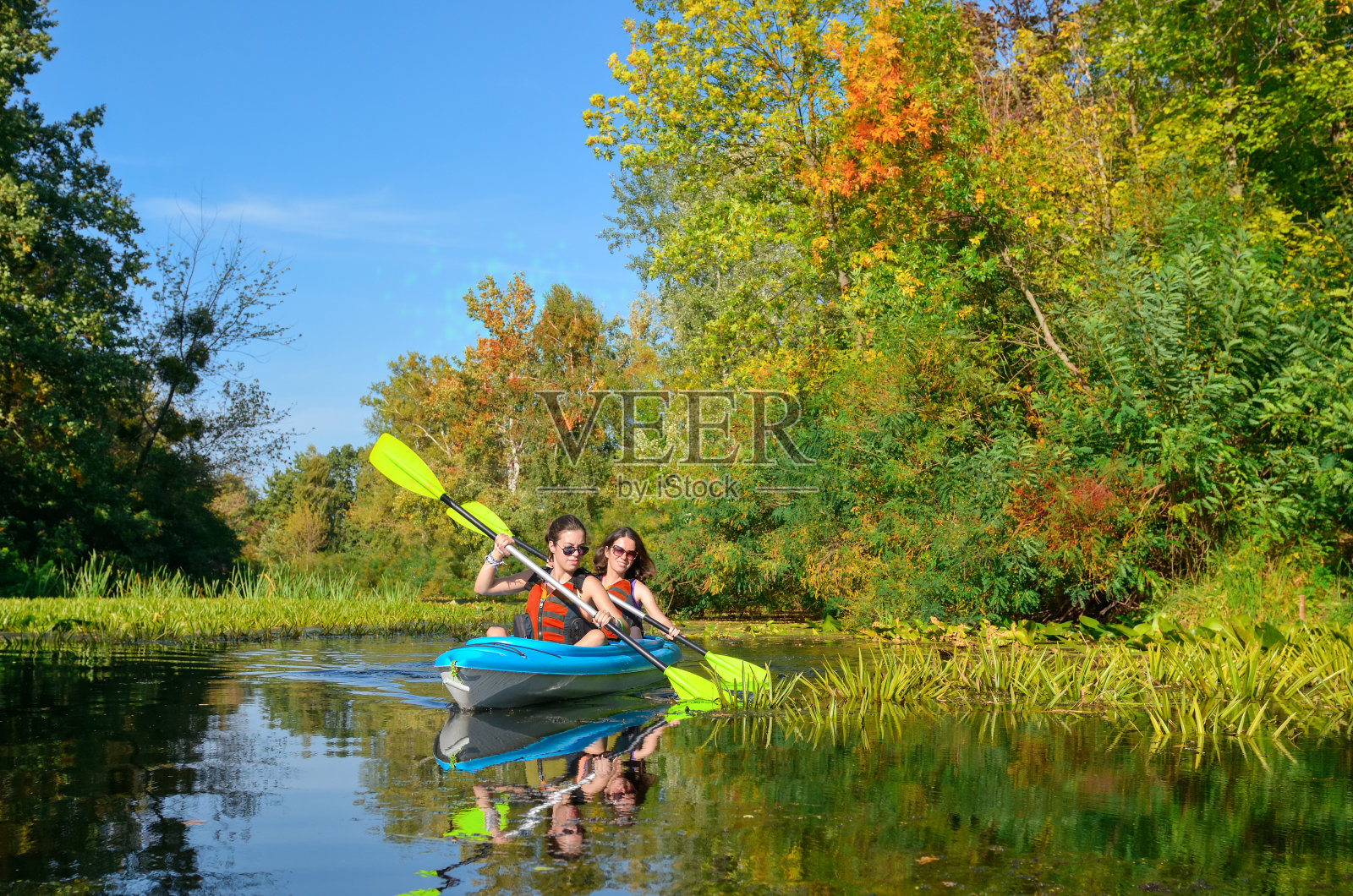 家庭皮划艇，母子皮划艇河上独木舟之旅，活跃的秋季周末和假期，运动和健身的概念照片摄影图片