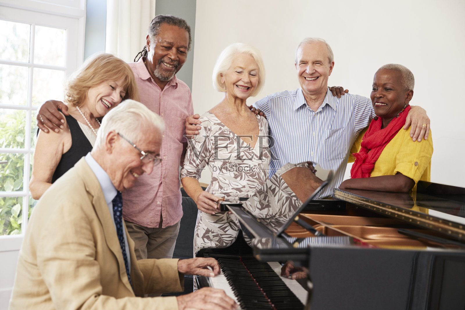 一群老年人站在钢琴旁一起唱歌照片摄影图片