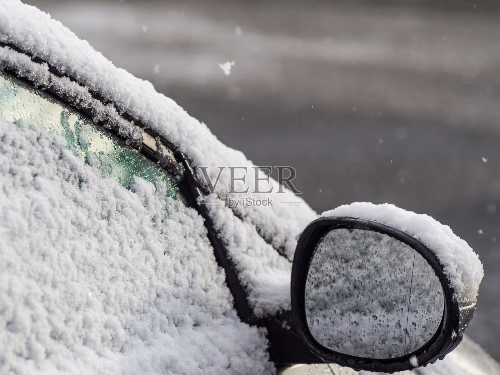 雪花飘落，覆盖着车窗和镜子照片摄影图片