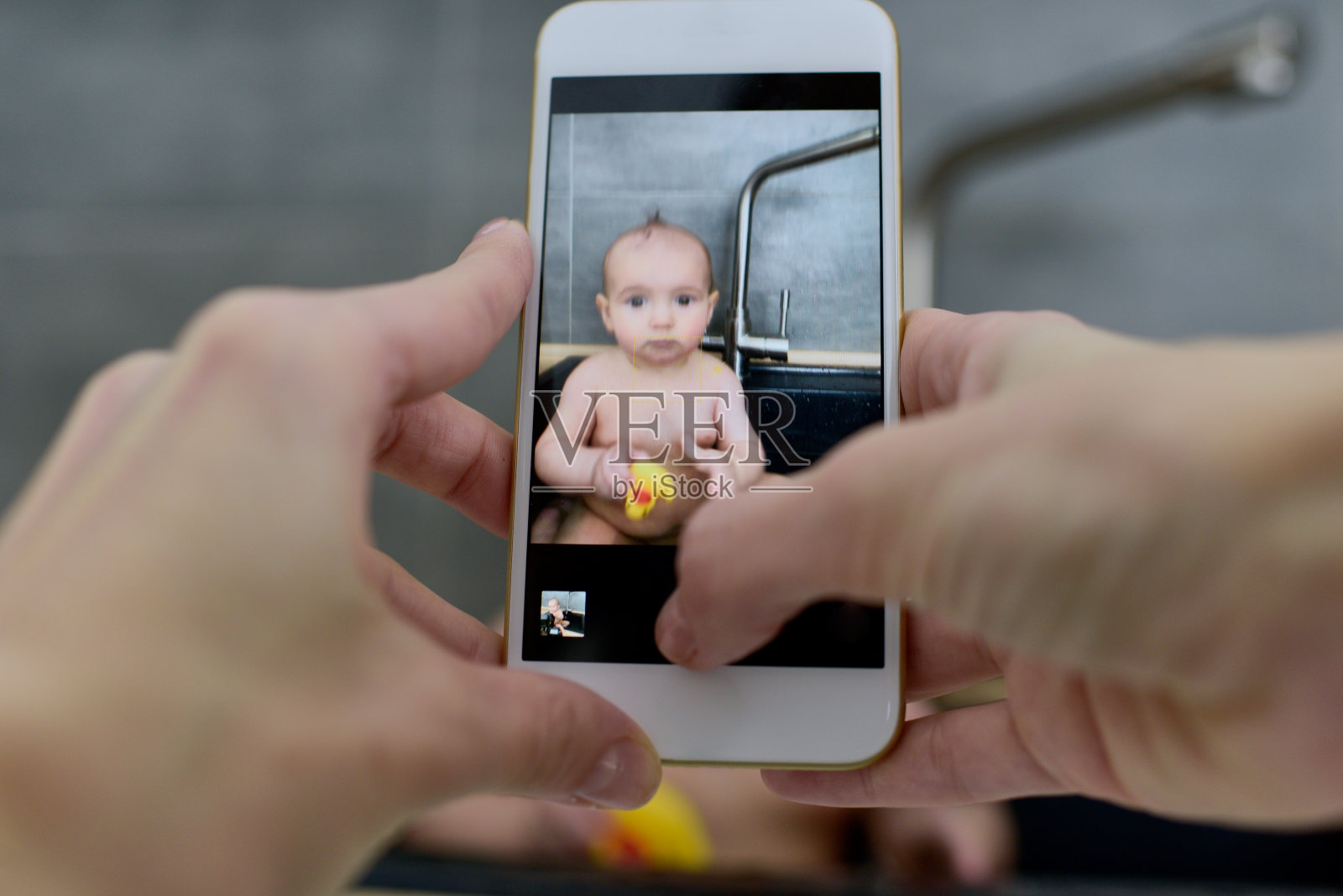 在水槽里拍摄婴儿和玩具照片摄影图片