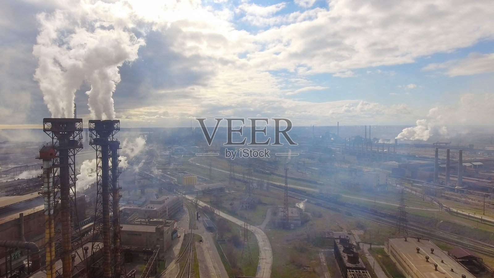 工业钢铁厂鸟瞰图。天线采用工厂。飞过烟雾缭绕的钢铁厂管道。环境污染。烟照片摄影图片
