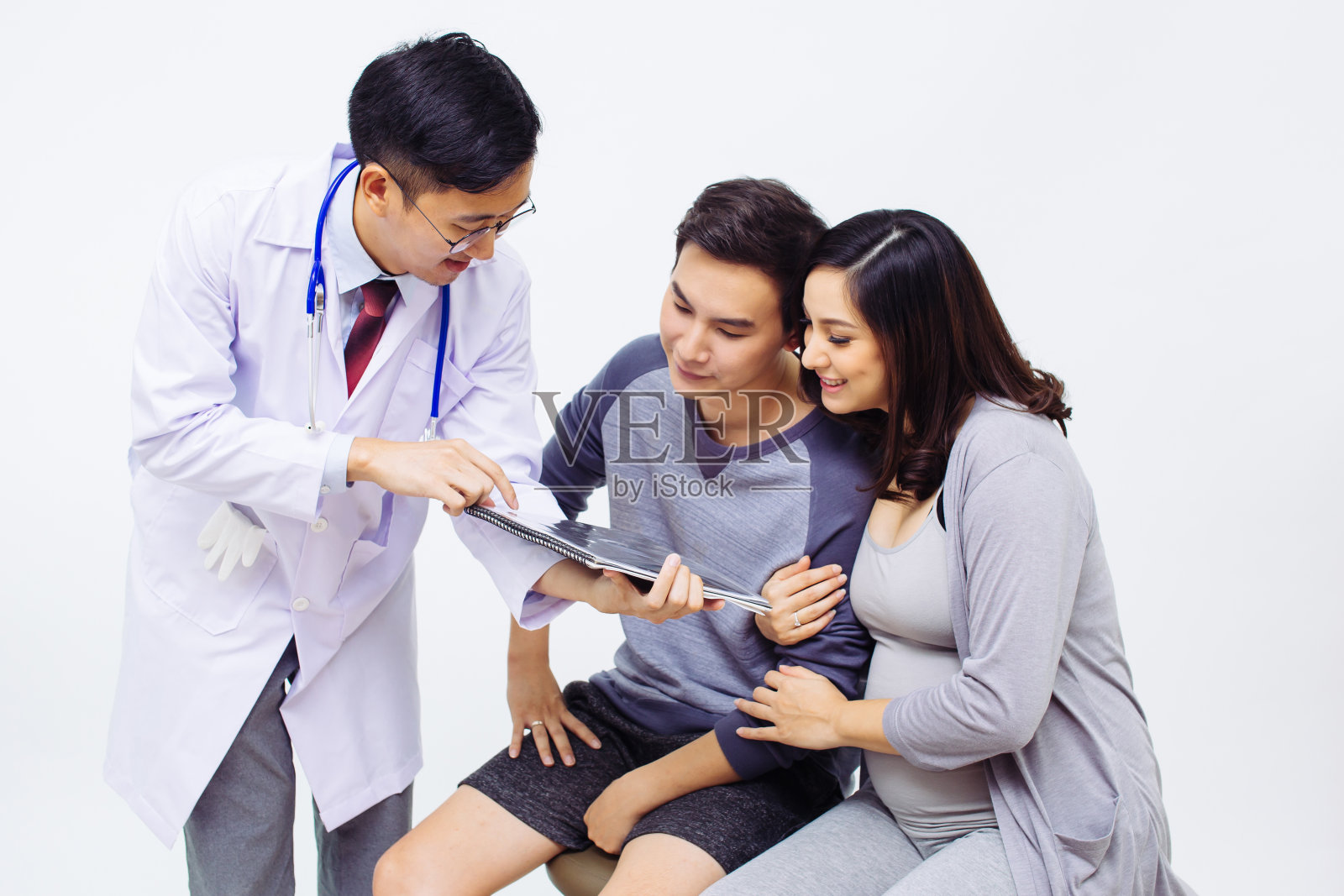 妇科医生或产科医生向一对夫妇展示超声波照片的孕妇和丈夫照片摄影图片