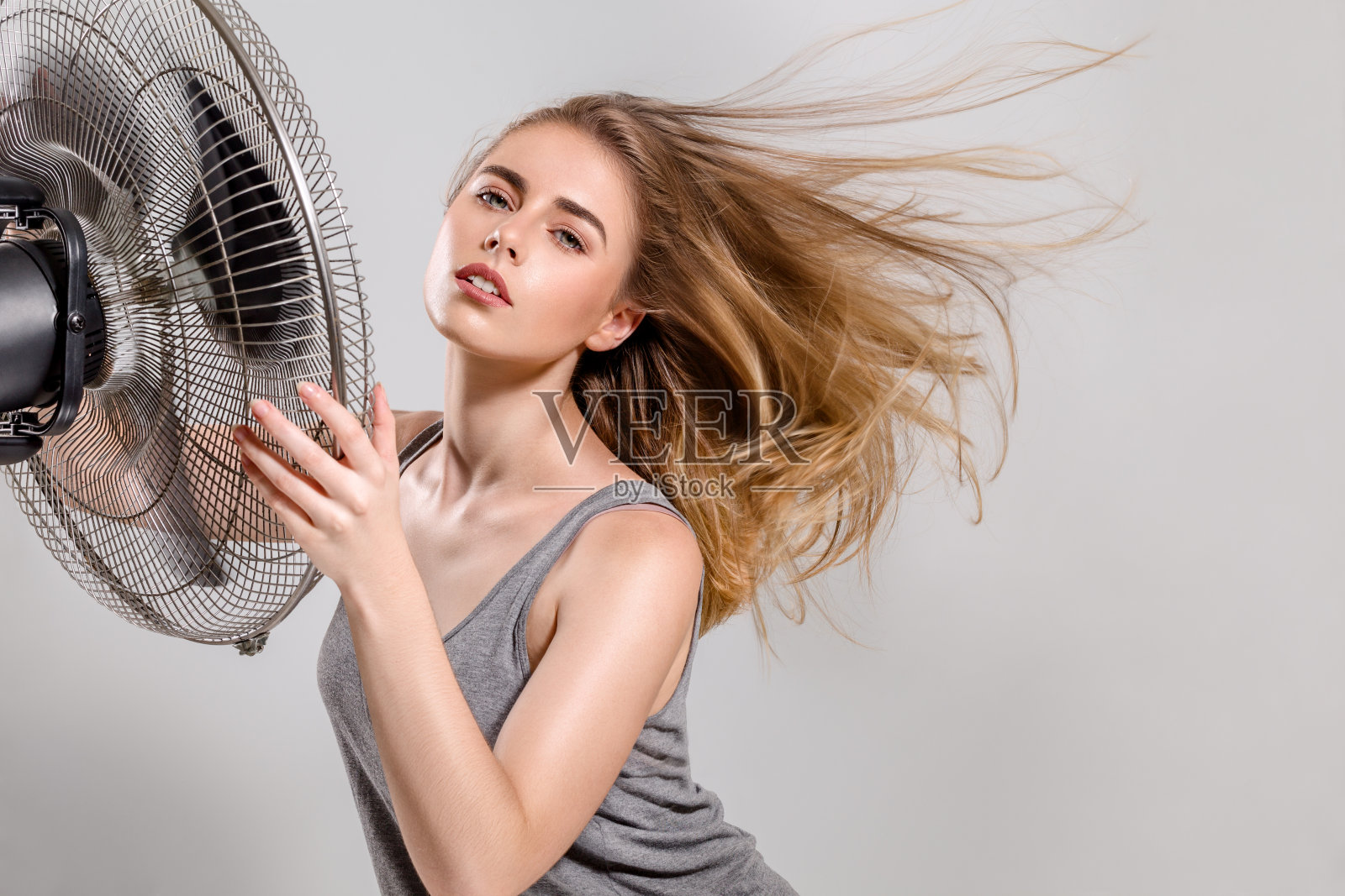 年轻女子用冷却器风扇照片摄影图片