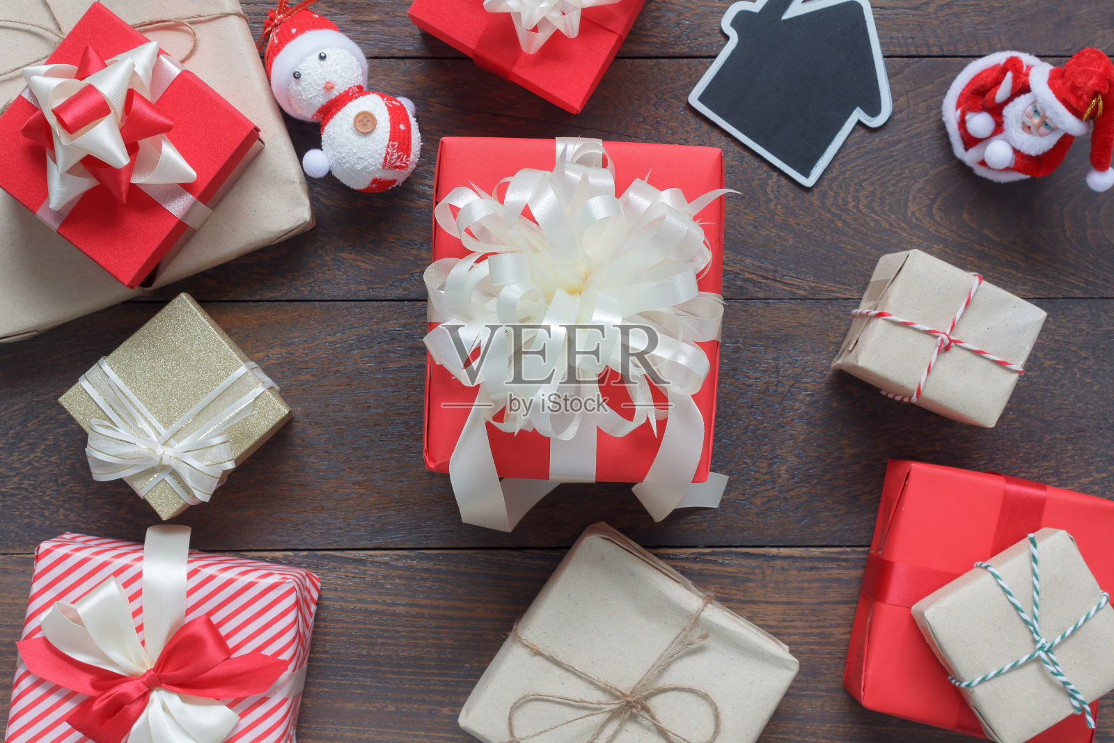桌面视图的形象装饰圣诞快乐和新年快乐的背景概念。许多美丽的礼品盒和装饰品装饰在现代棕色木制的家庭办公工作室。照片摄影图片