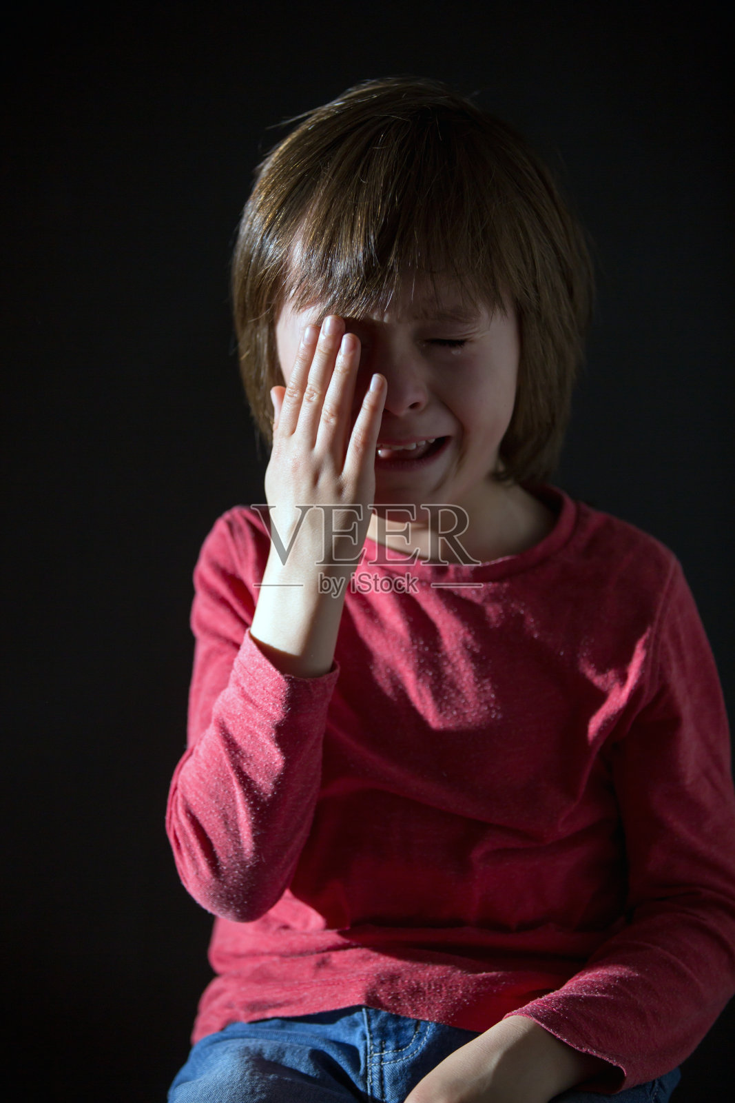 可怜的小孩，哭闹着，抱着毛绒玩具照片摄影图片