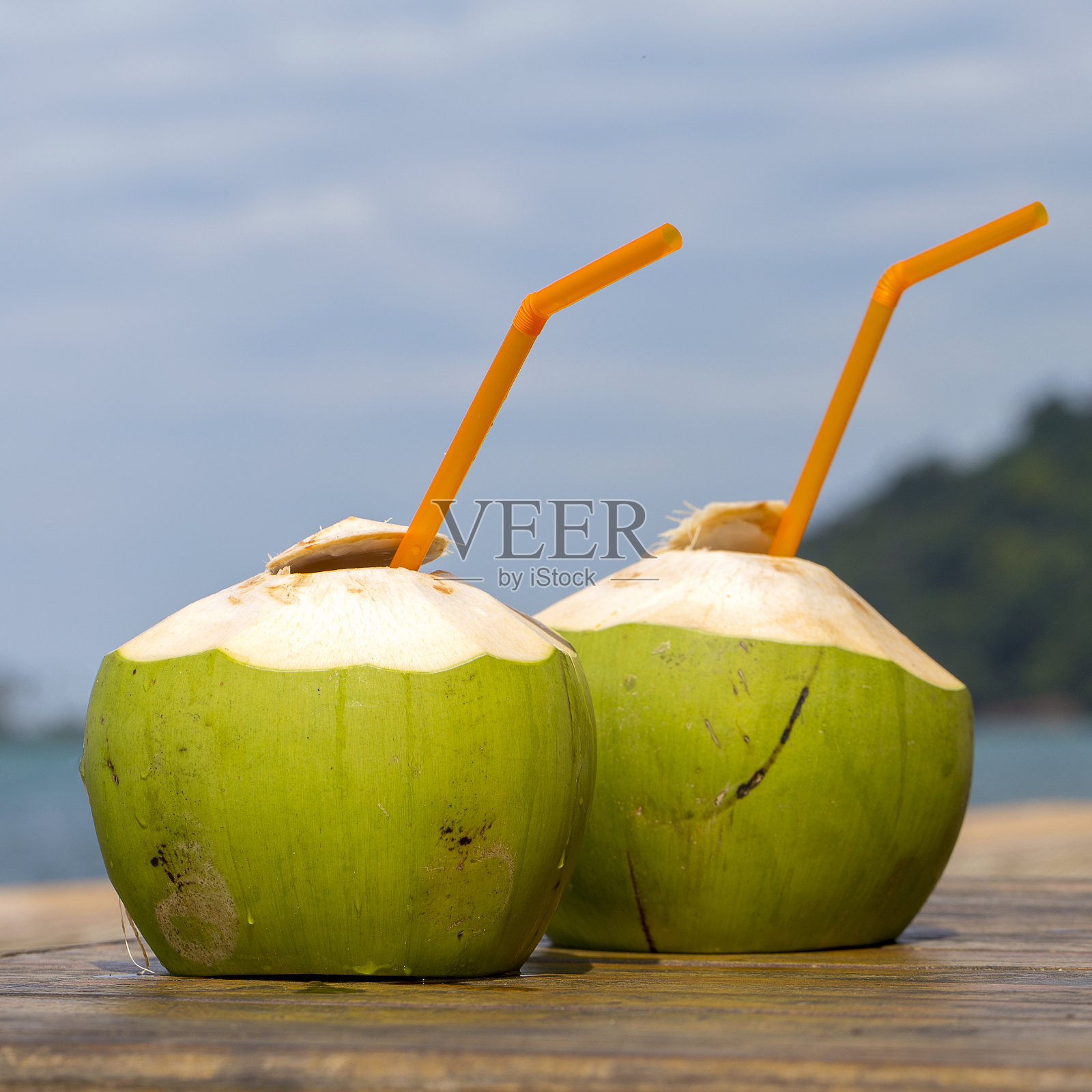 热带海滩咖啡馆的桌子上放着两杯椰子汁照片摄影图片