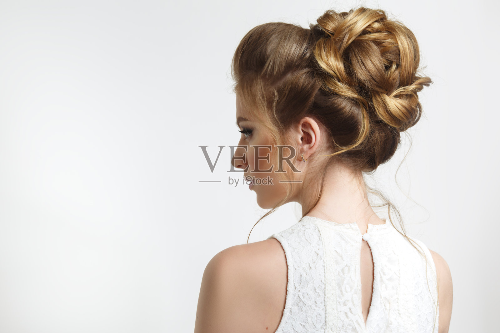 优雅的婚礼发型上的美丽新娘的侧面。照片摄影图片