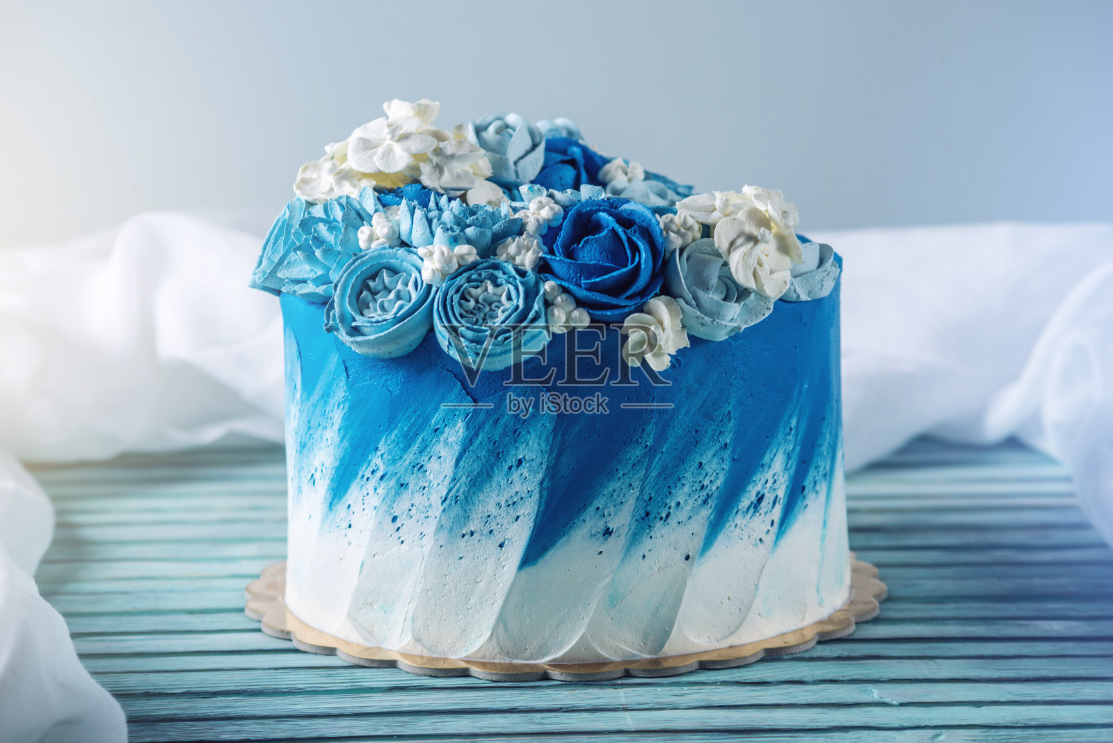 漂亮的蓝色婚礼蛋糕装饰白色的奶油花。生日甜点的概念照片摄影图片