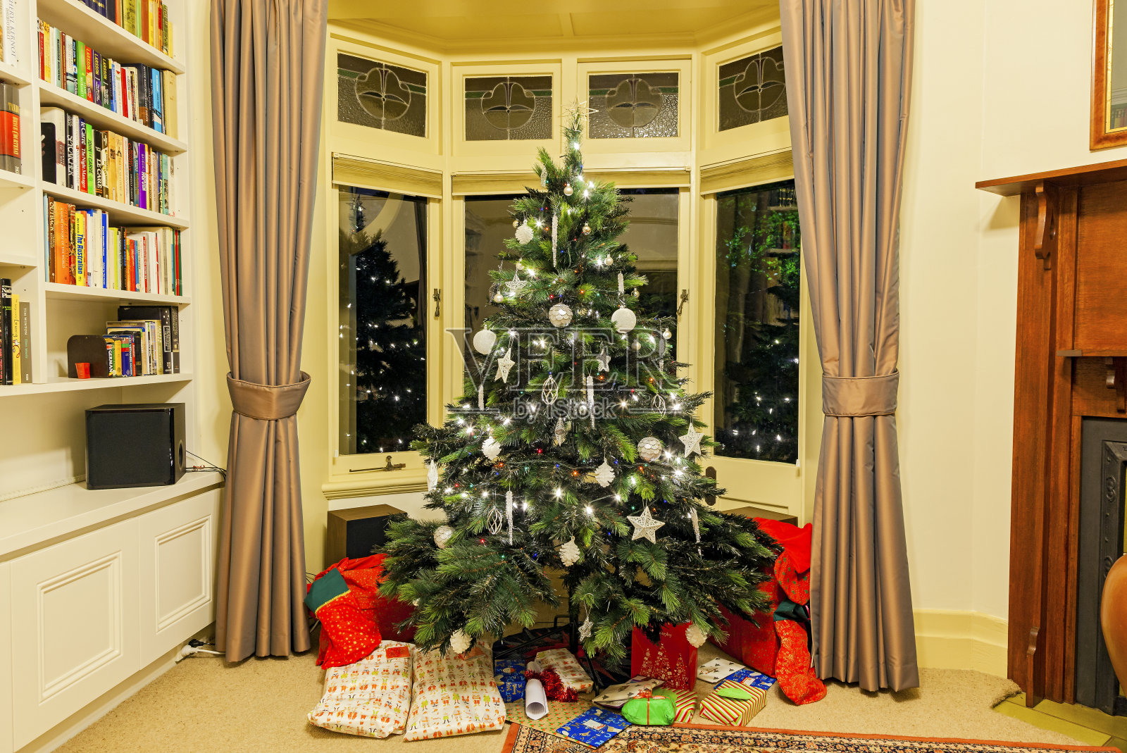 圣诞家居装饰:圣诞树与礼物点燃在晚上照片摄影图片