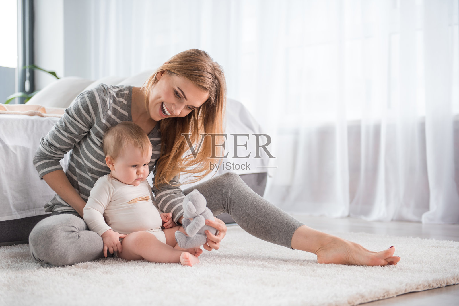妈妈笑着和宝宝在地毯上玩照片摄影图片