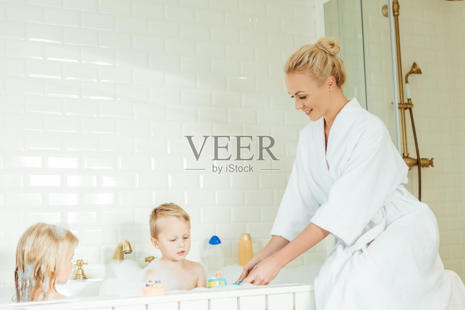 妈妈用泡泡浴给婴儿洗澡。水的乐趣。照片摄影图片_ID:305298042-Veer图库