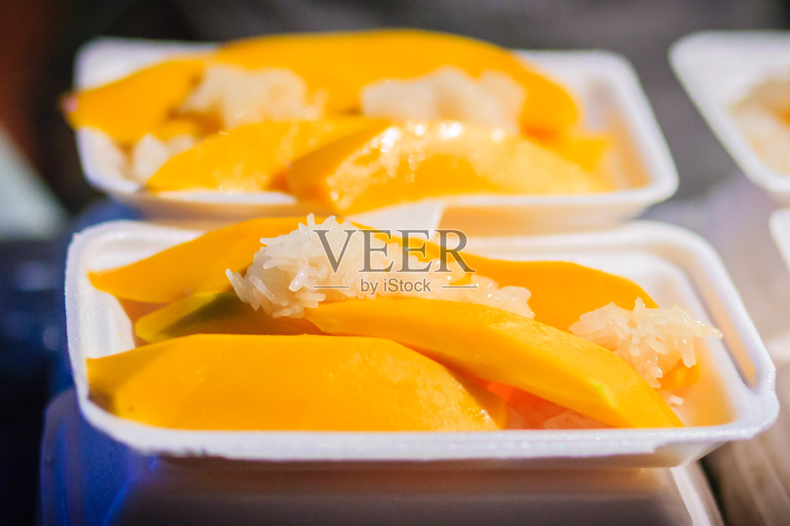 在泰国曼谷考山路夜市，芒果配糯米和新鲜果汁是很受欢迎的街头小吃。照片摄影图片