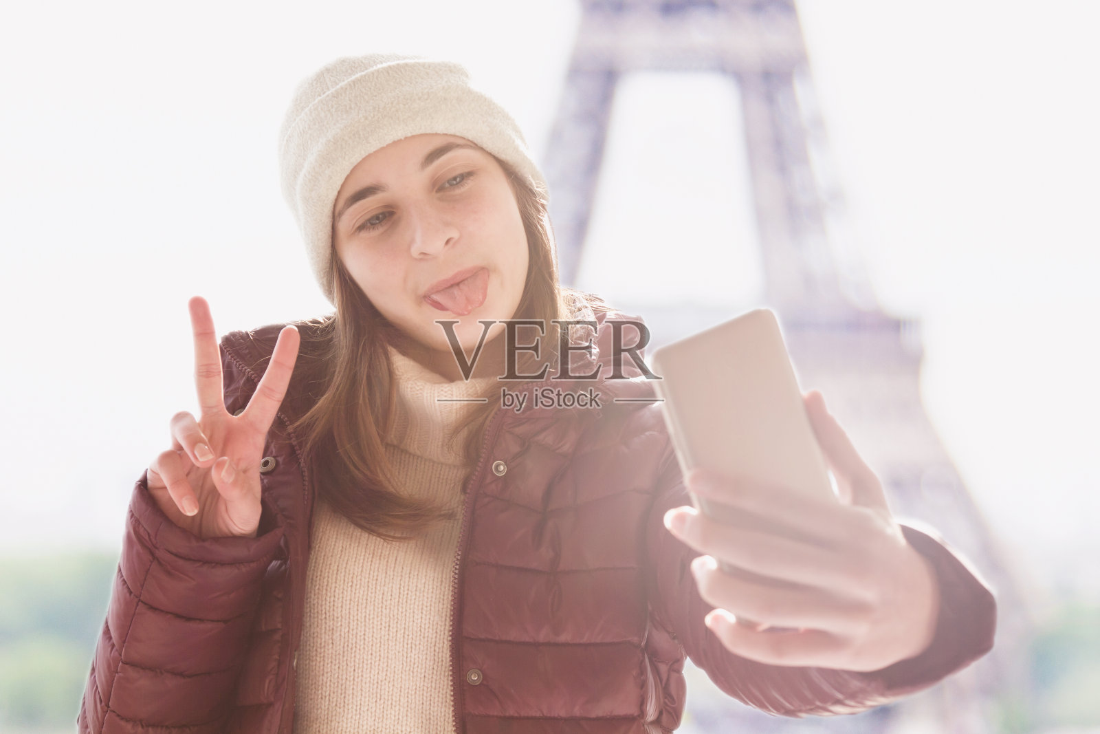 在法国巴黎的一个下雪天，一个小女孩正在自拍。照片摄影图片