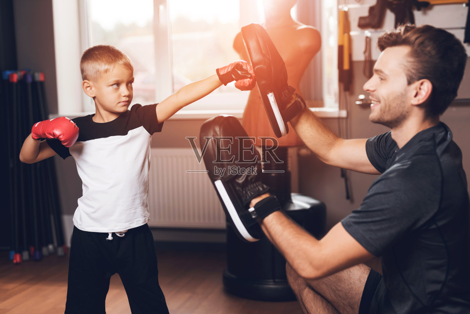 父亲和儿子在健身房。父亲和儿子一起度过时间，过着健康的生活方式。照片摄影图片