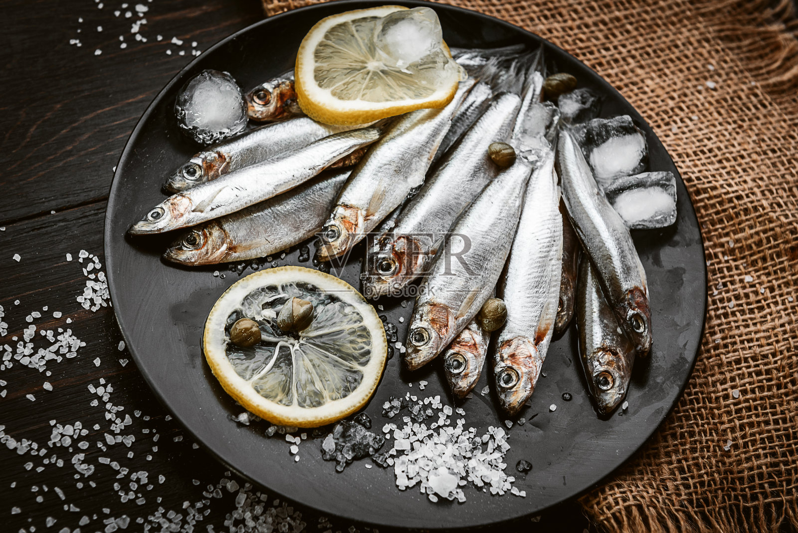 新鲜的生鱼片，配以盐和柠檬，以一种乡村风格放在木板上照片摄影图片