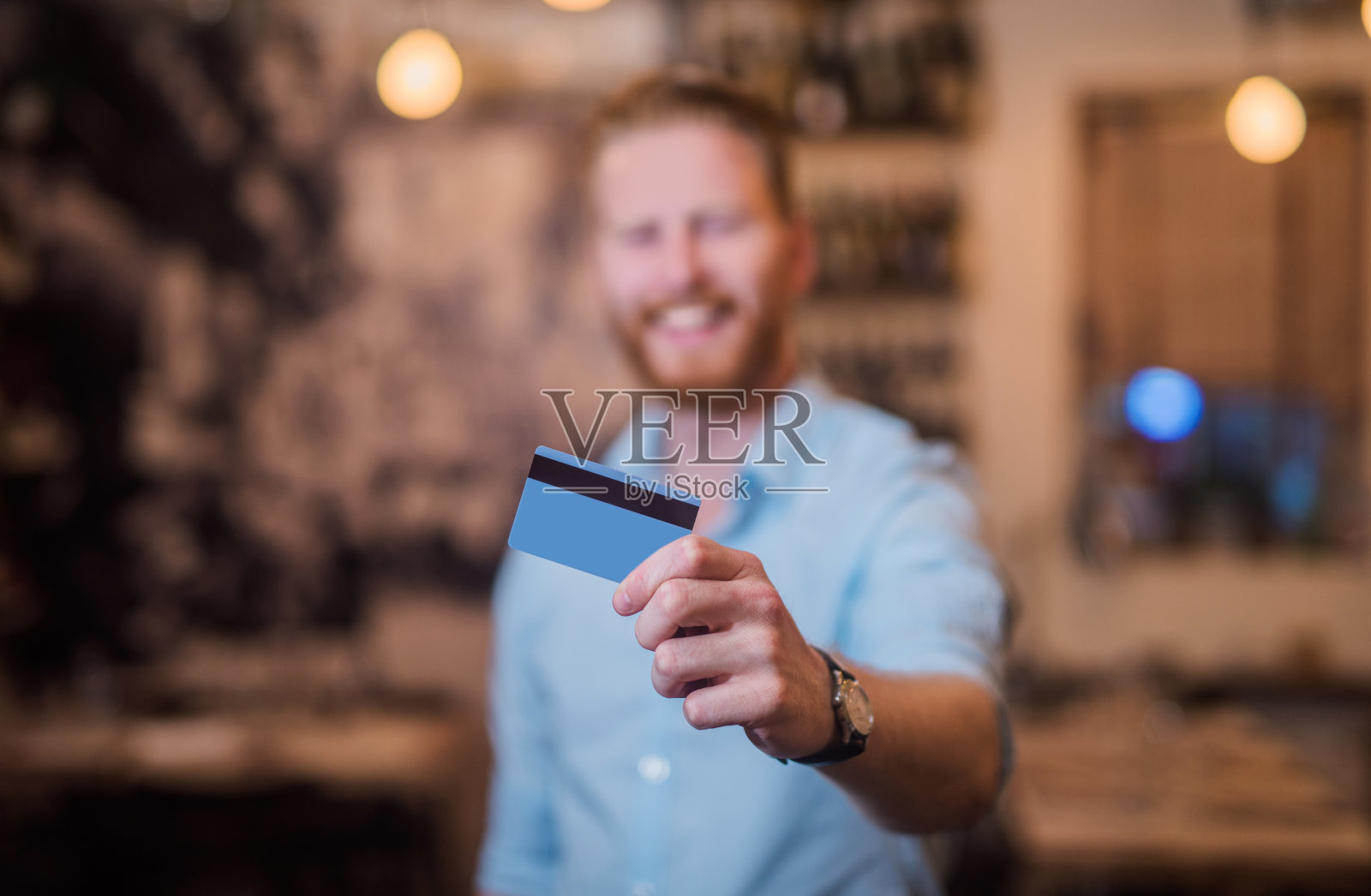 兴高采烈的年轻企业家拿着一张信用卡。照片摄影图片