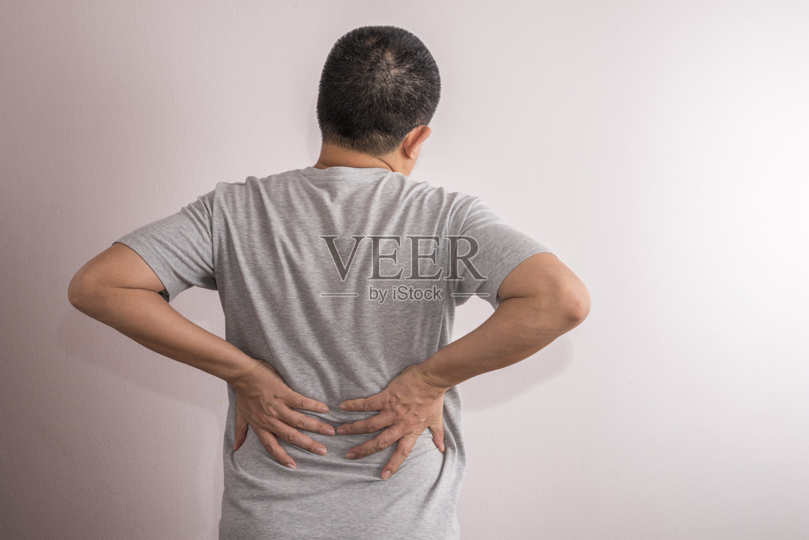 背痛的亚洲男人。缓解疼痛的概念照片摄影图片