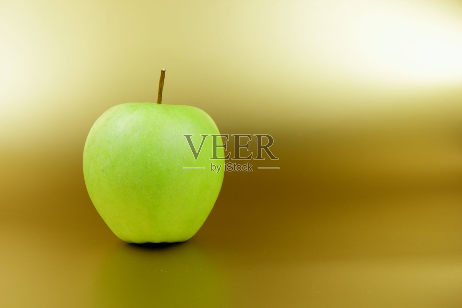 绿苹果在金色的背景，绿水果在黄色的背景，苹果流行艺术，维生素，健康的生活方式，素食主义，极简主义照片摄影图片