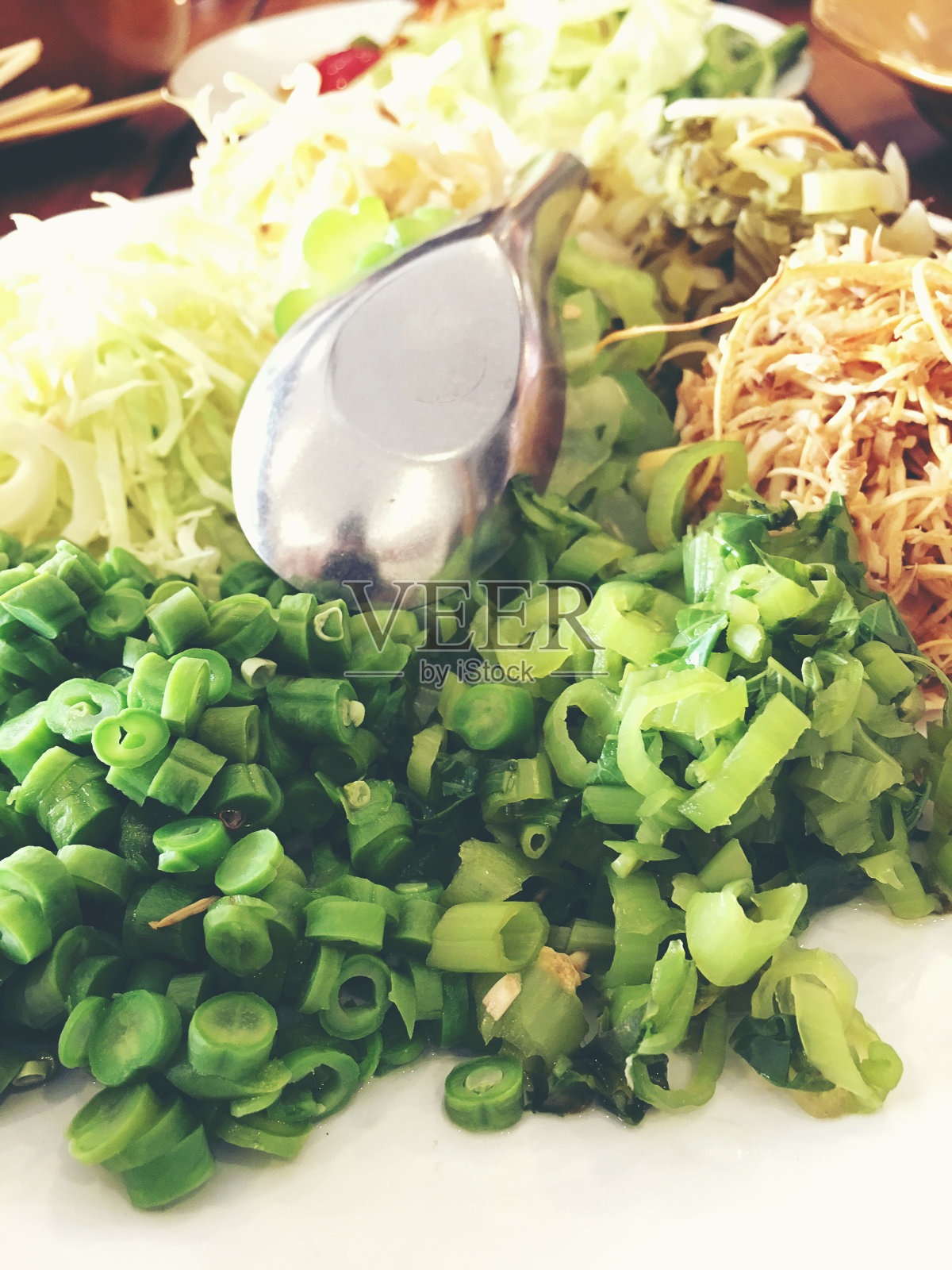 各种当地蔬菜与咖喱米粉和混合多种酱料制成的泰国米粉放在木桌上，是泰国著名的食物。-一套泰国菜。(泰国北部风格)。照片摄影图片