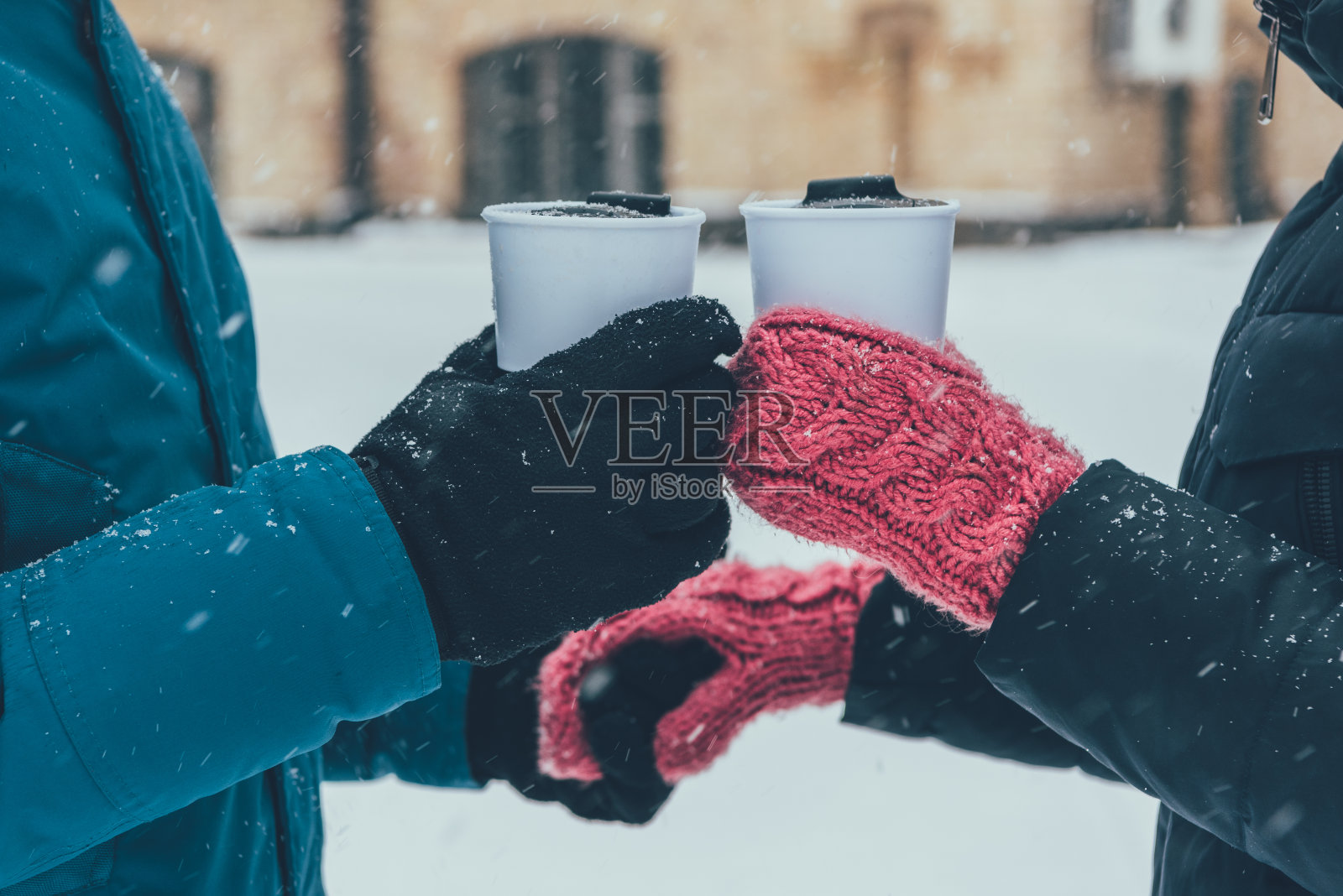 一对夫妇手拿热饮在冬天的街道上照片摄影图片
