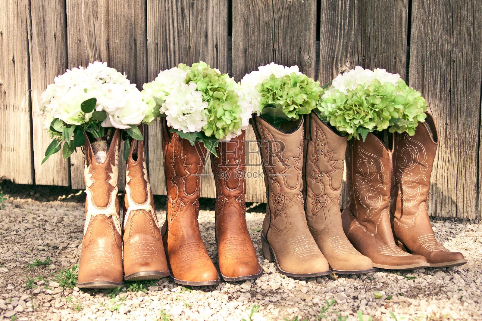乡村主题婚礼上的牛仔靴和花束照片摄影图片